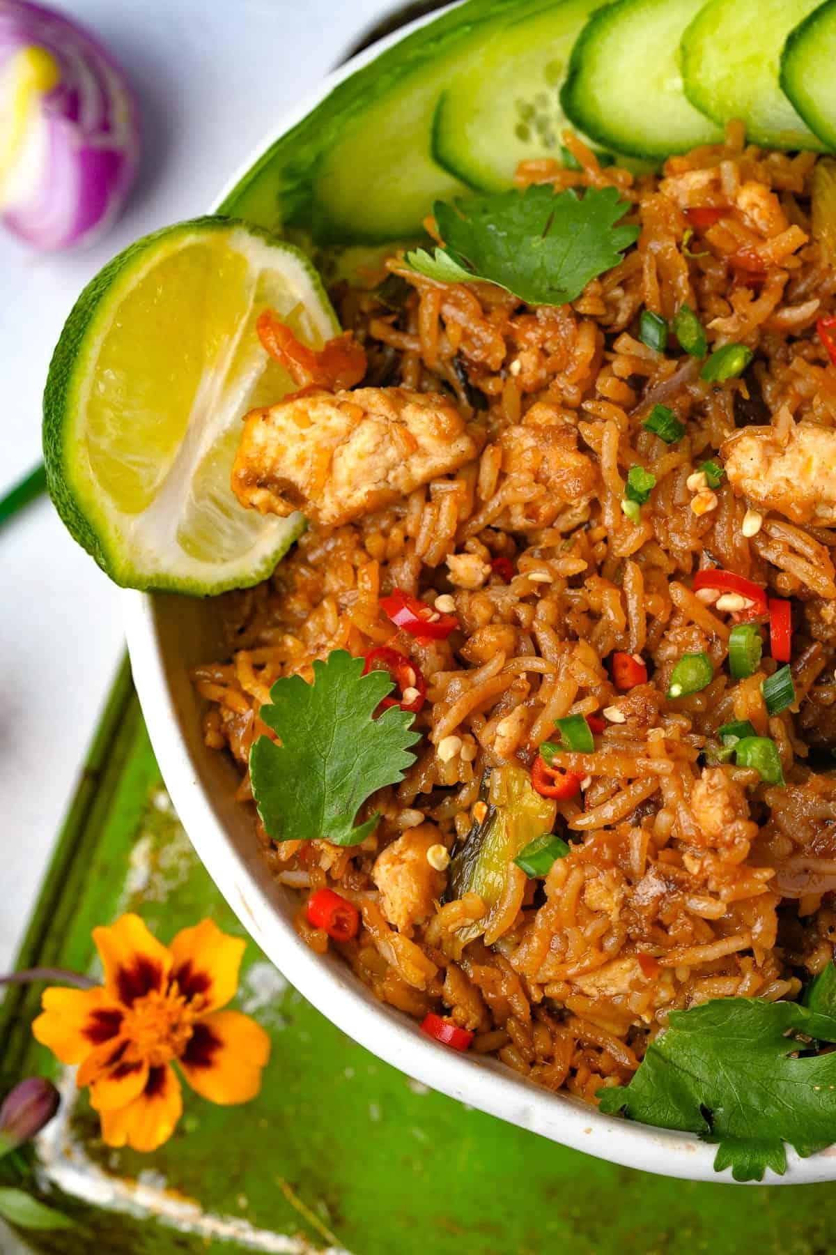 A vibrant and delicious Tom Yum Rice Bowl, garnished with fresh herbs and lime wedges