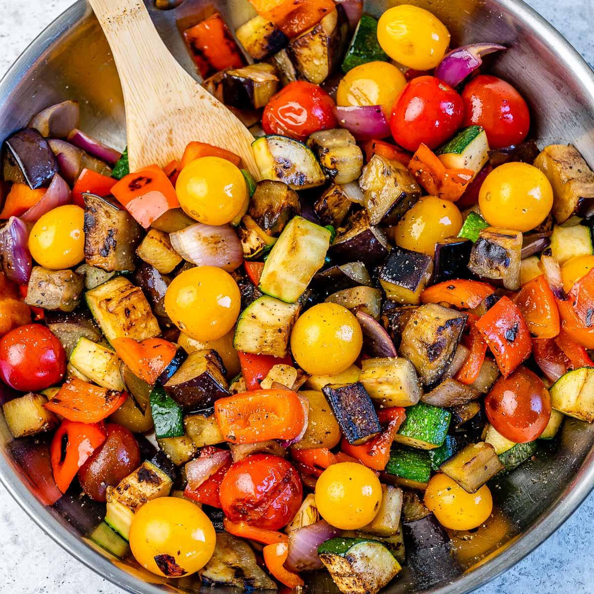 A serving of ratatouille and kale stir-fry garnished with fresh basil