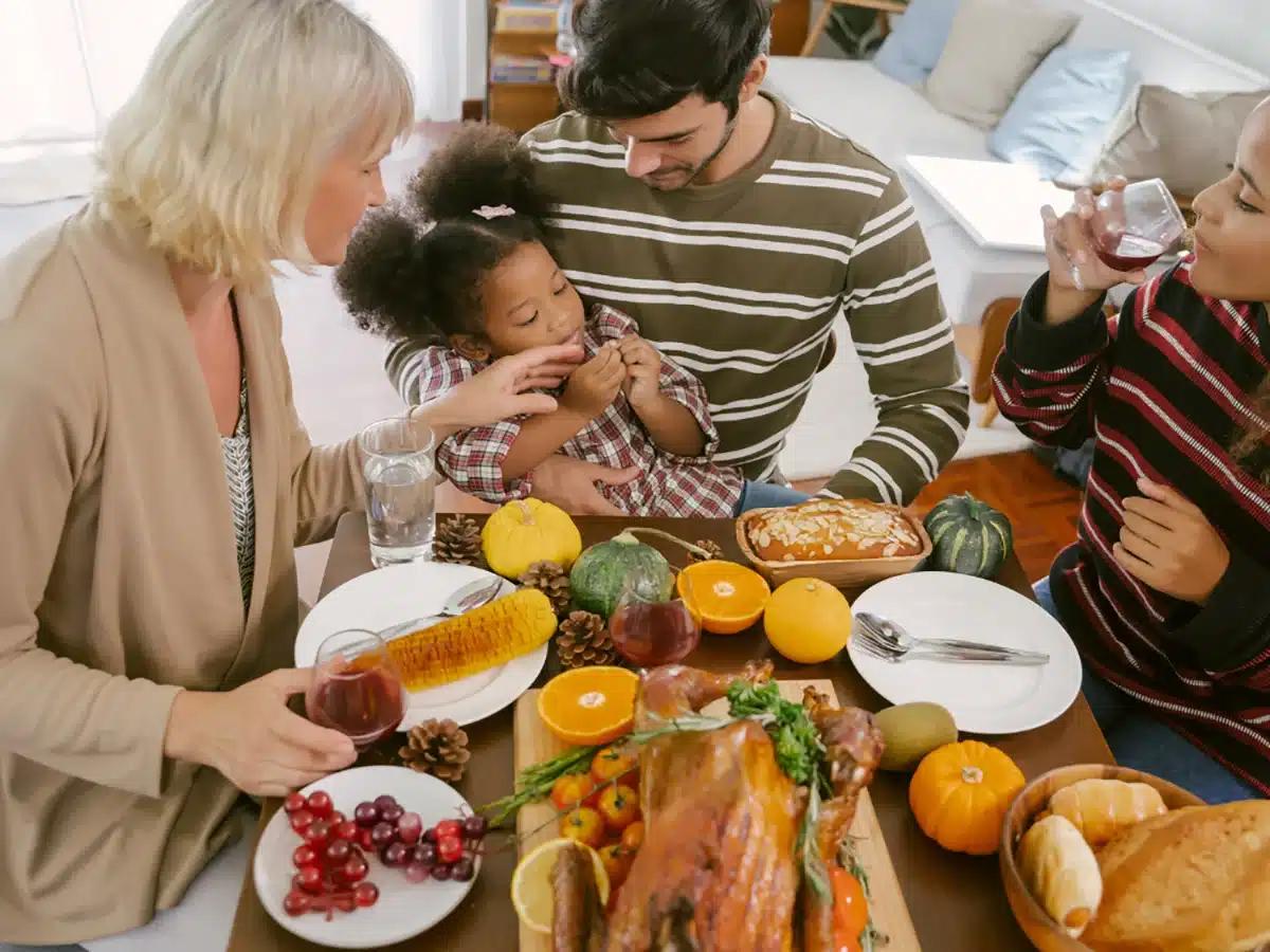 Happy family gathered around a table with a roasted turkey, laughing and sharing food