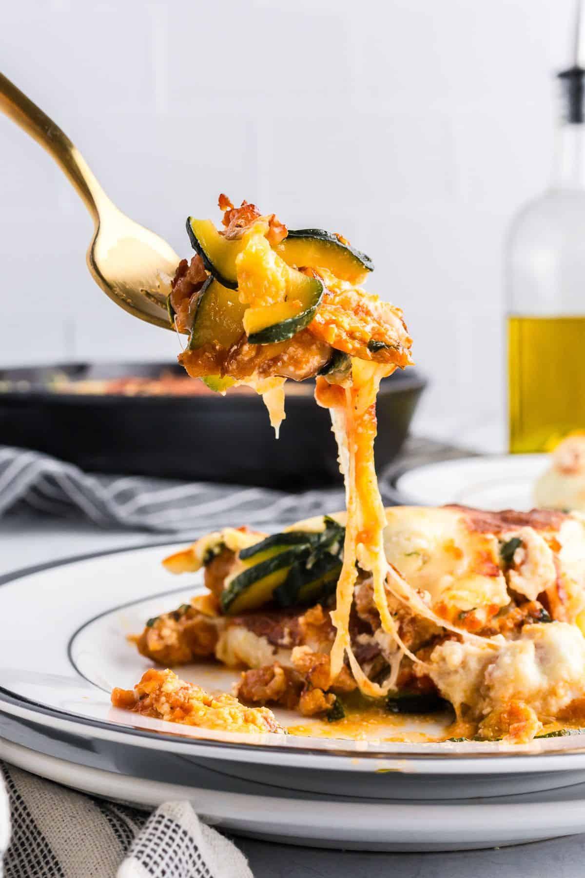 Close-up of a single serving of zucchini lasagna with a focus on the layers and the melted pepper jack cheese sauce.