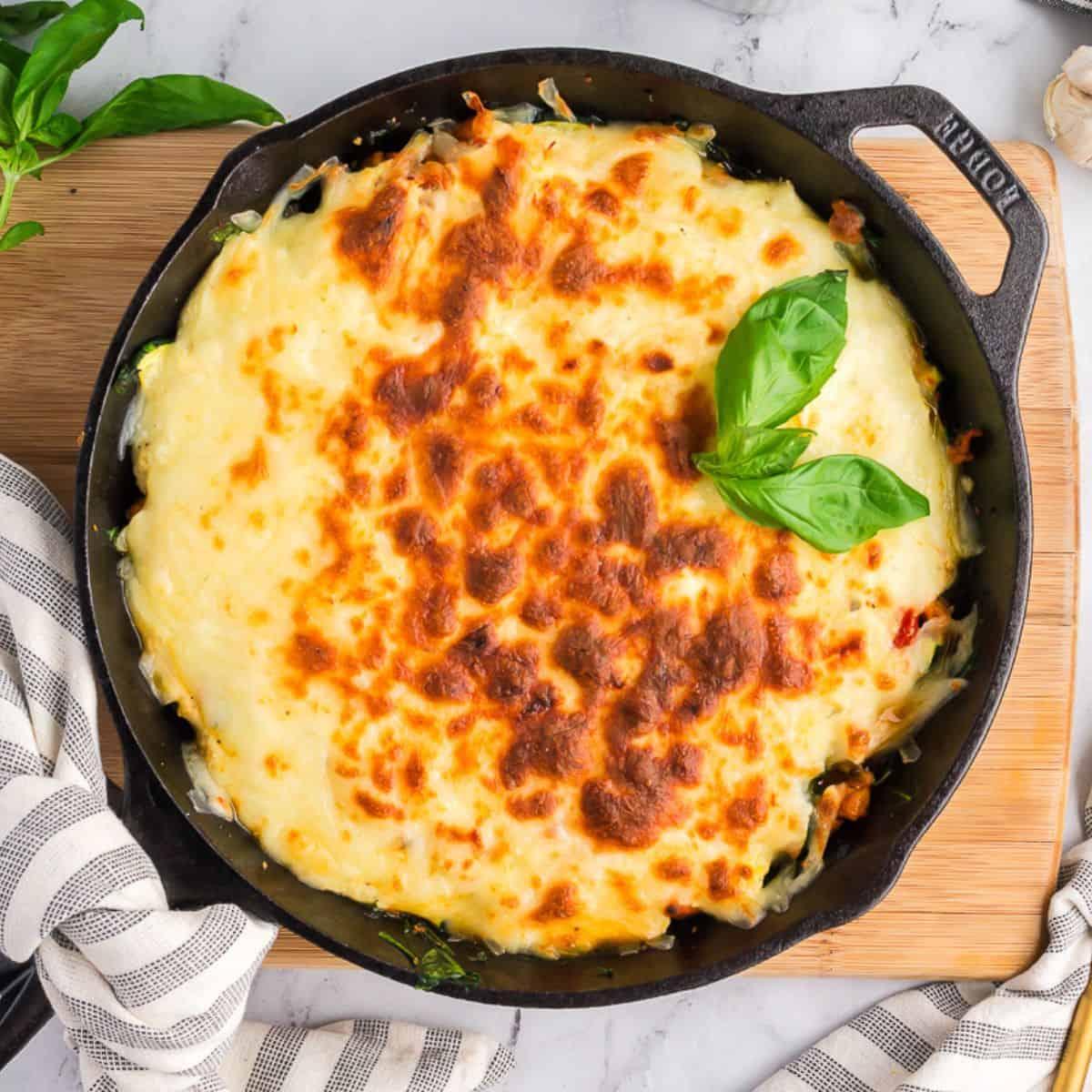 A delicious-looking zucchini lasagna, freshly baked and golden brown, garnished with fresh basil leaves
