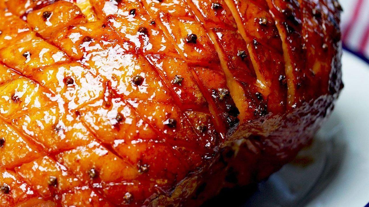 Close-up shot of the maple-mustard glaze being brushed onto the ham