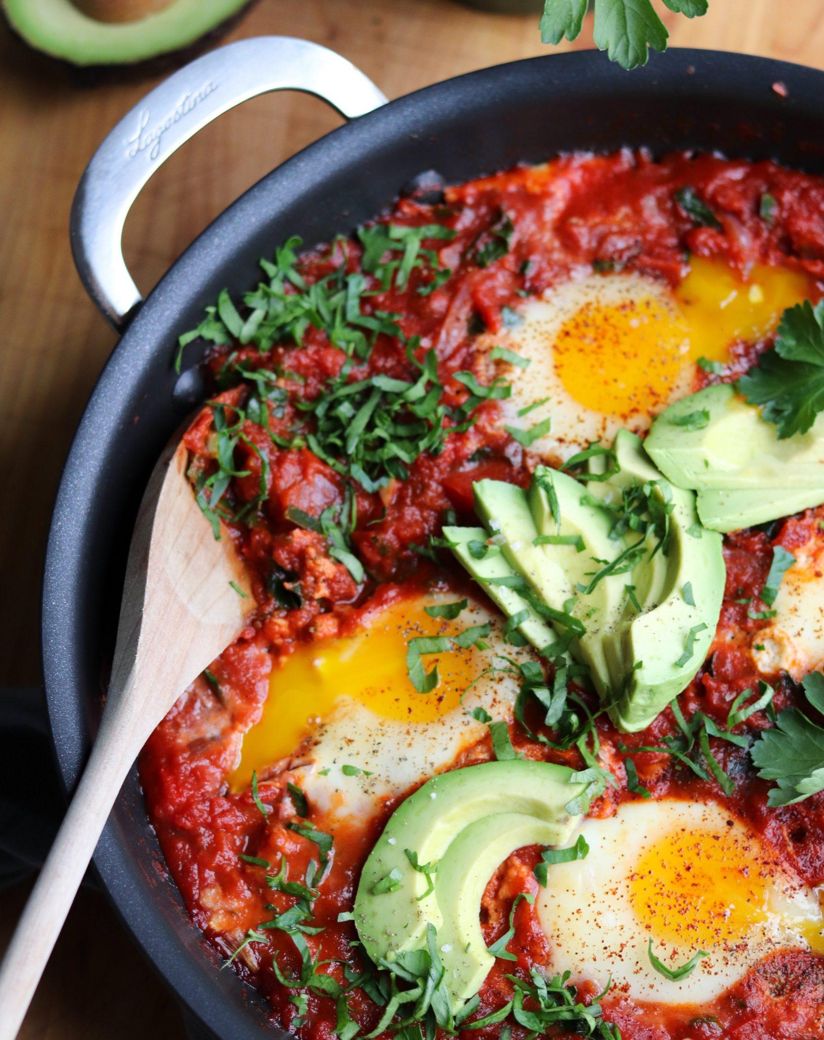 Skillet of simmering shakshuka with pepperoni, close-up view