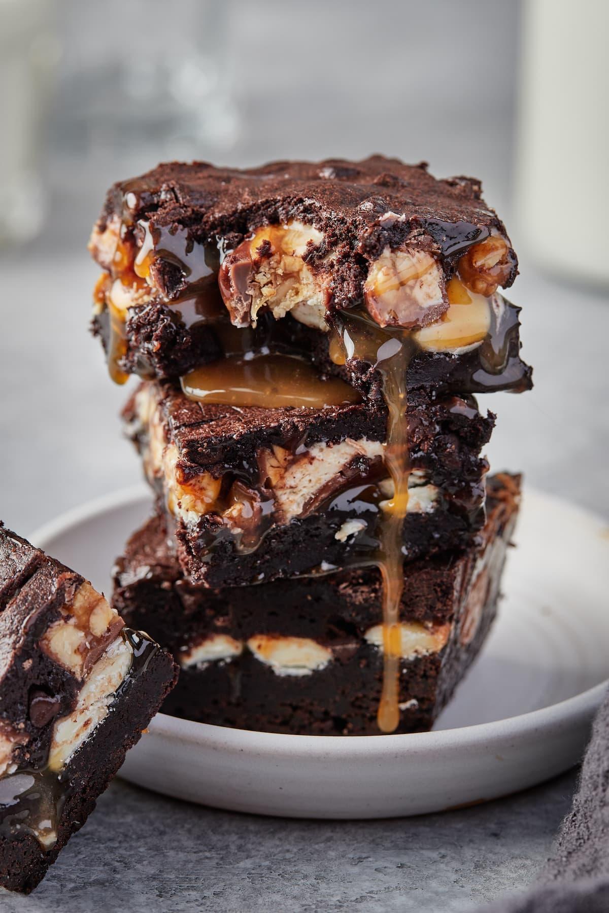 Someone taking a Snickers brownie from a plate