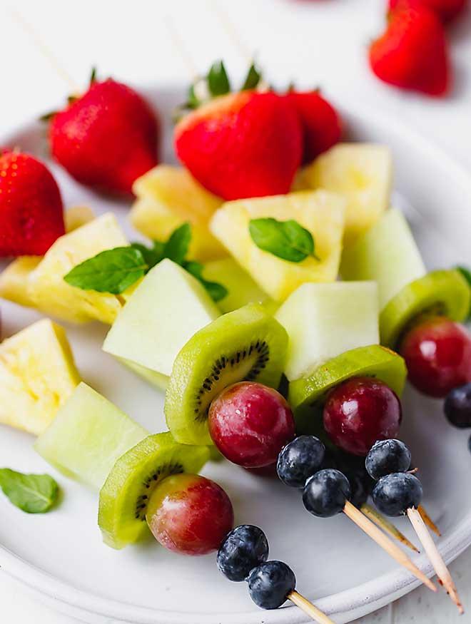 Fruit kebabs arranged on a plate, ready to be served