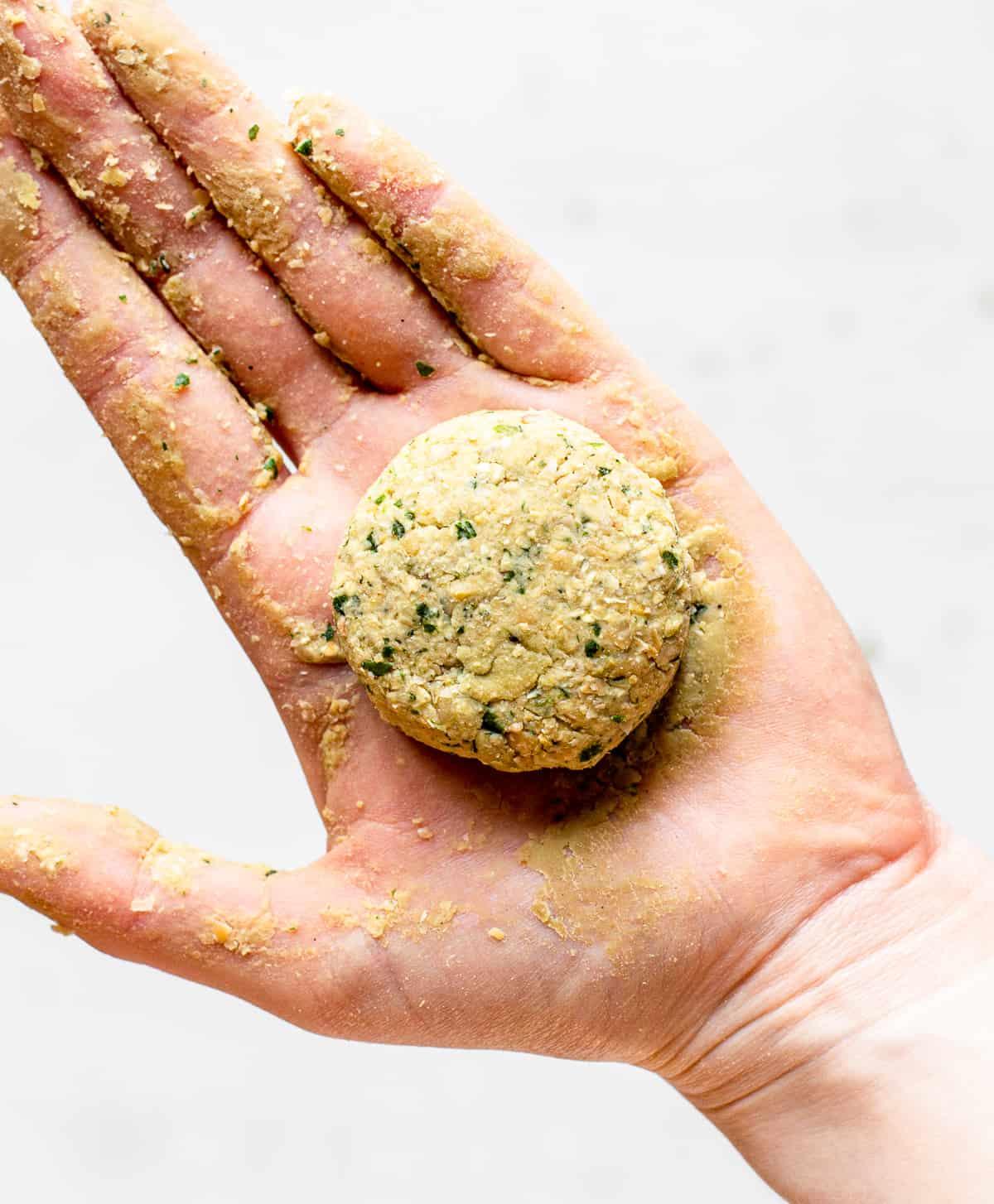 Close up shot of a hand forming falafel balls