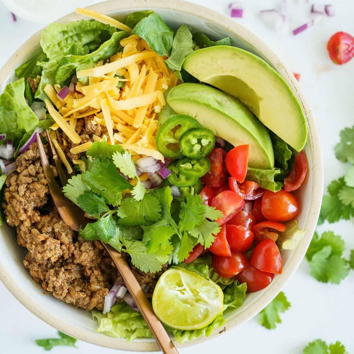 A close-up shot of a vibrant Tex-Mex Keto Avocado & Ground Beef Salad in a rustic bowl, showcasing the colorful ingredients.