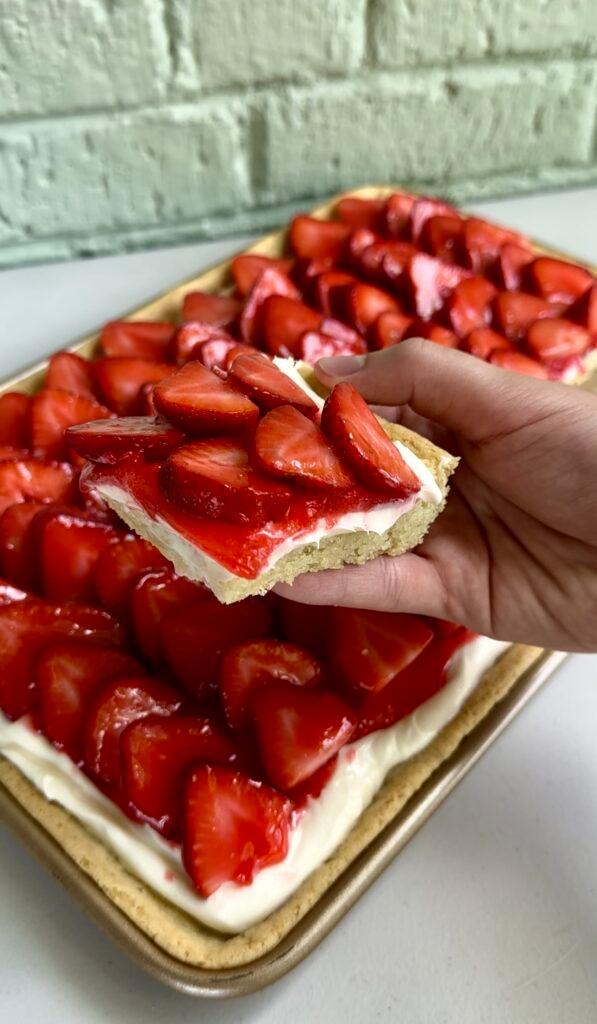 A delicious Strawberry Shortcake Pizza with fresh strawberries and whipped cream on a sugar cookie crust