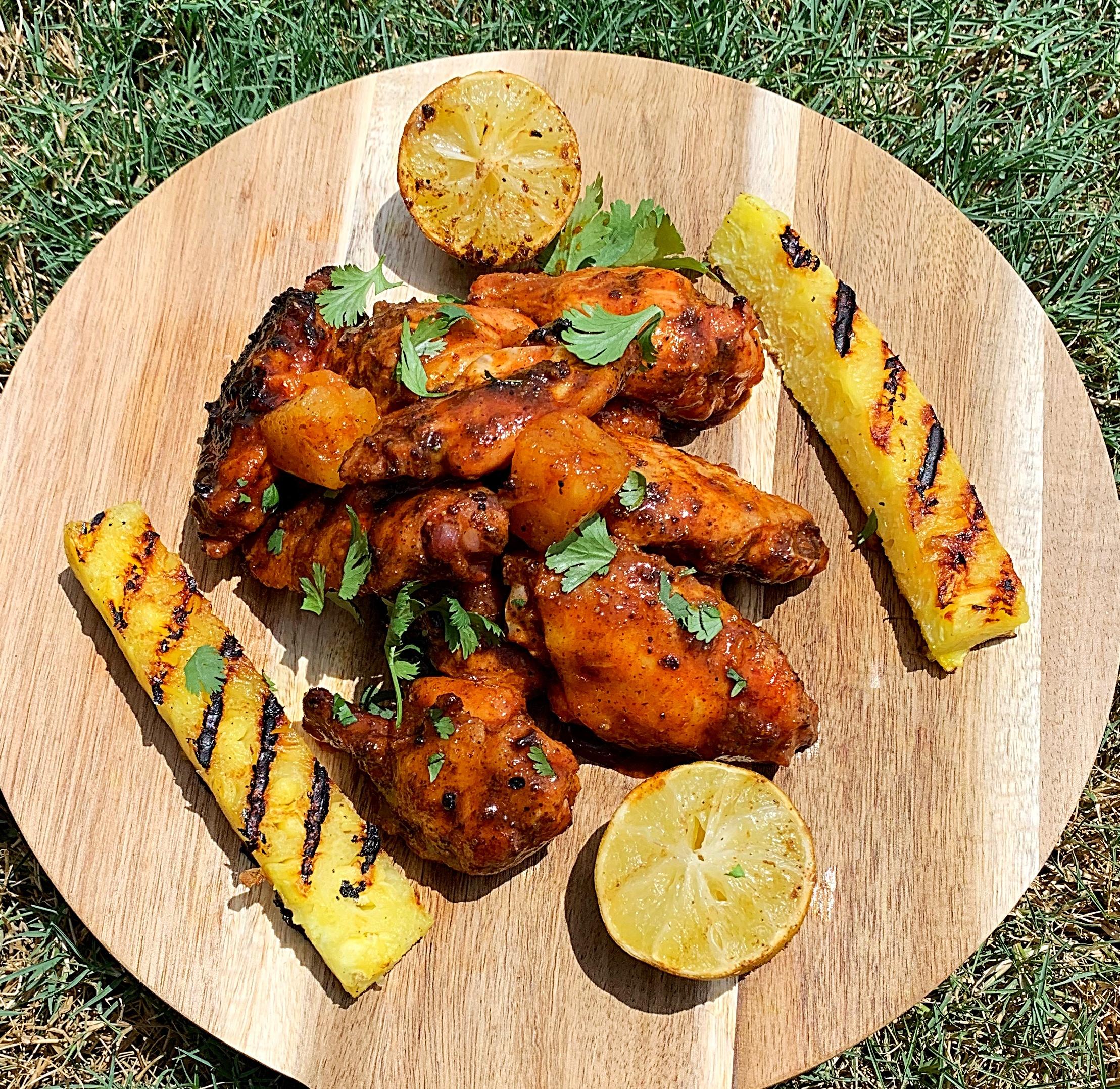 Close up of delicious spicy pineapple habanero wings garnished with fresh lime zest