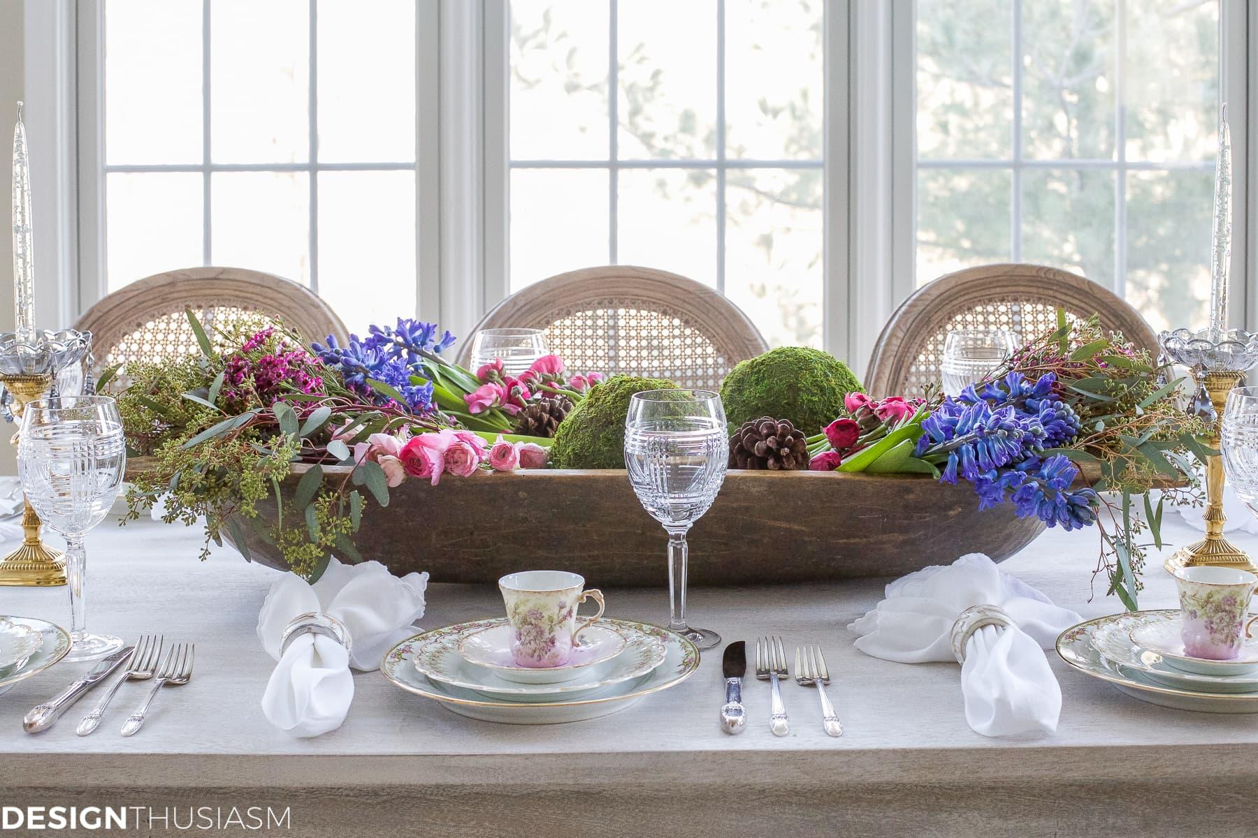 A beautifully set table with a rustic charm. A bowl of coq au vin takes center stage.