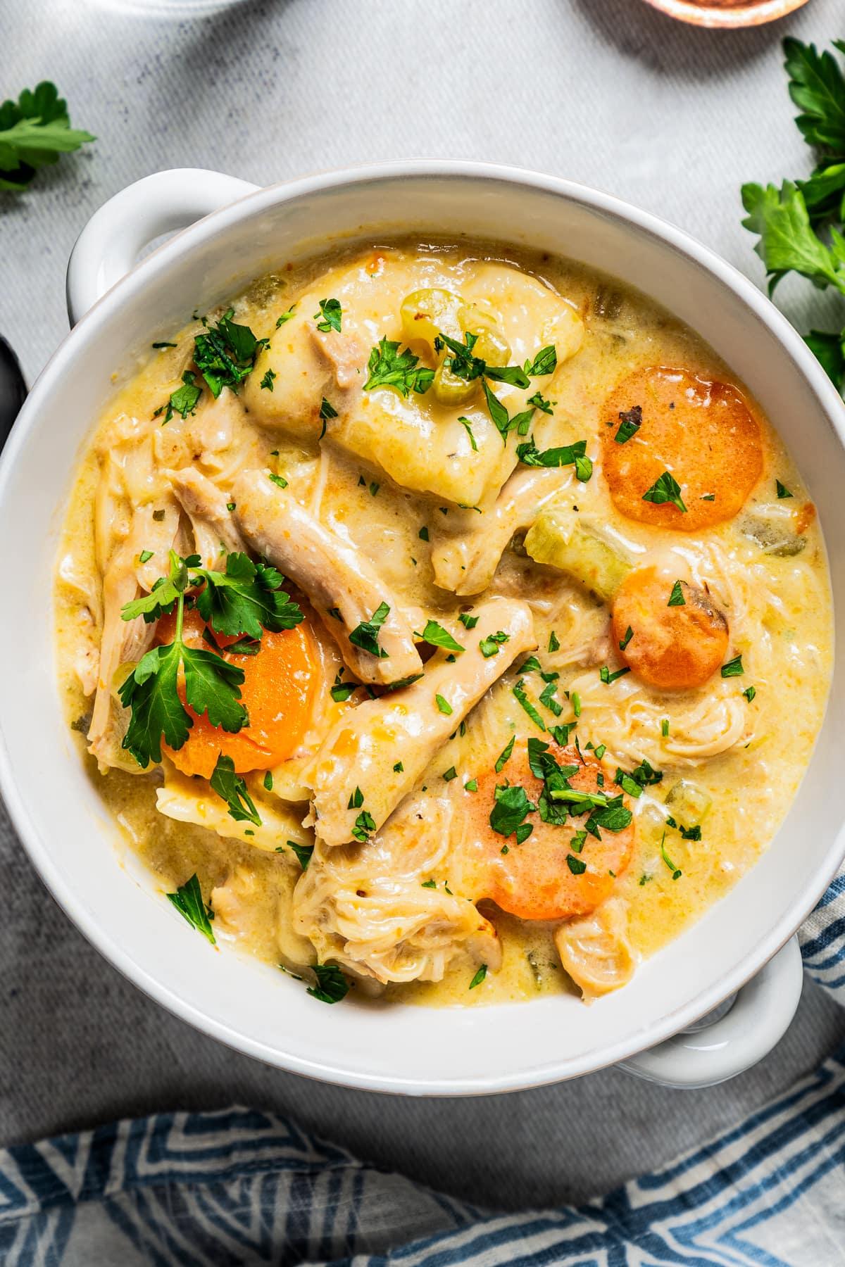 A steaming bowl of Instant Pot Chicken and Dumpling Soup with Thyme, garnished with fresh parsley.