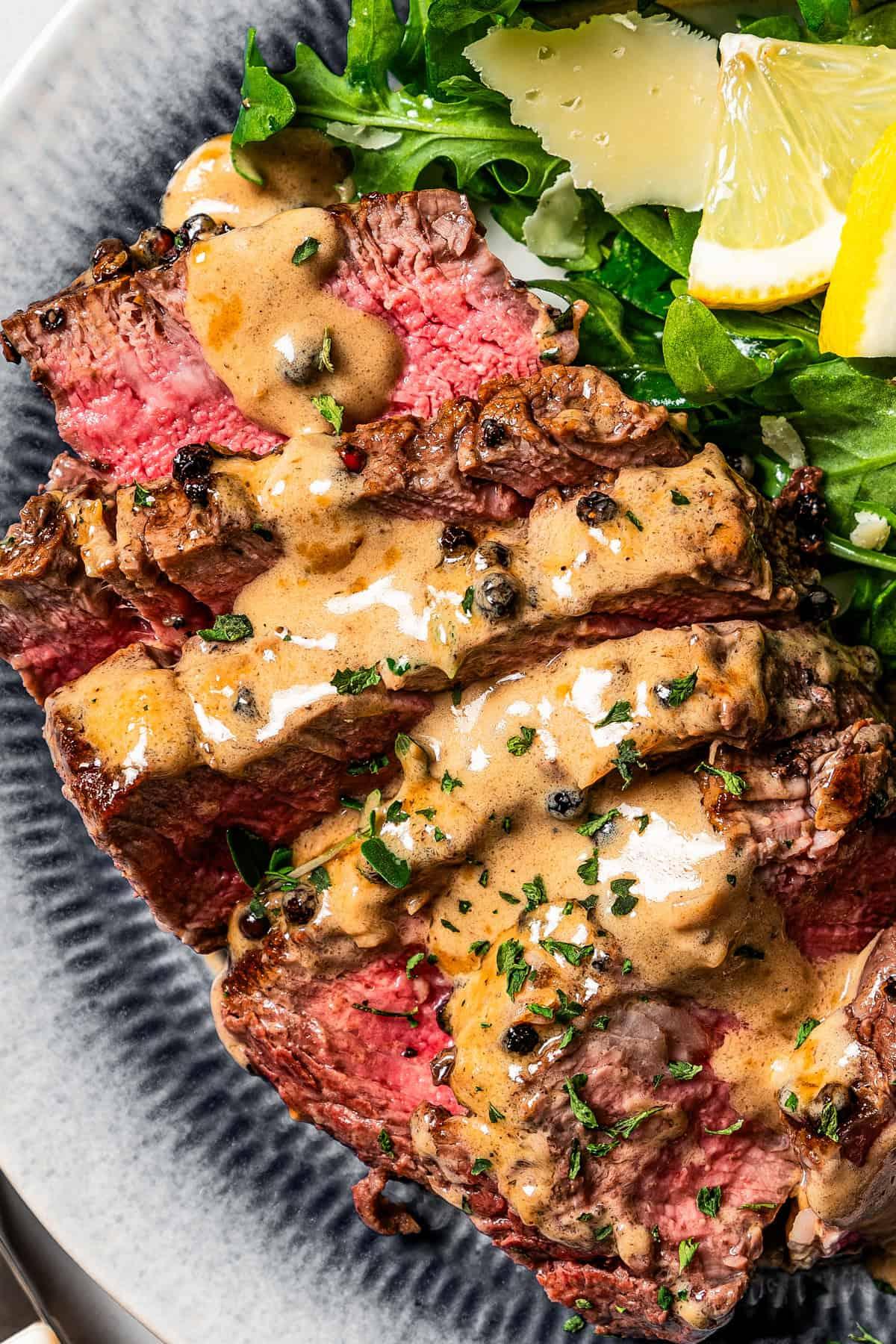 Close-up of a perfectly seared steak au poivre with a rich cognac cream sauce, garnished with fresh parsley