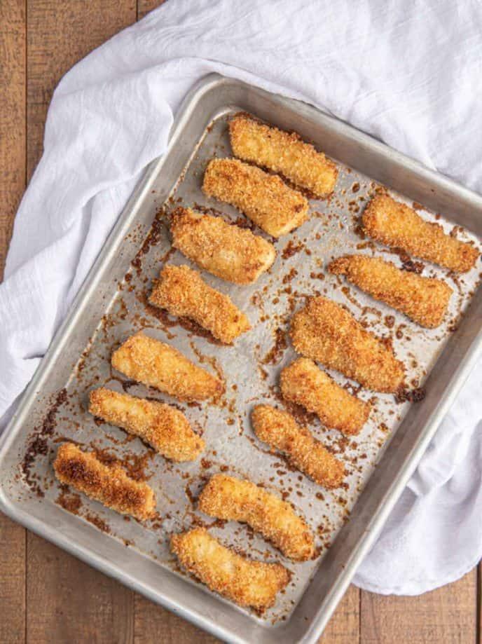 close-up shot of crispy baked fish sticks on a baking sheet