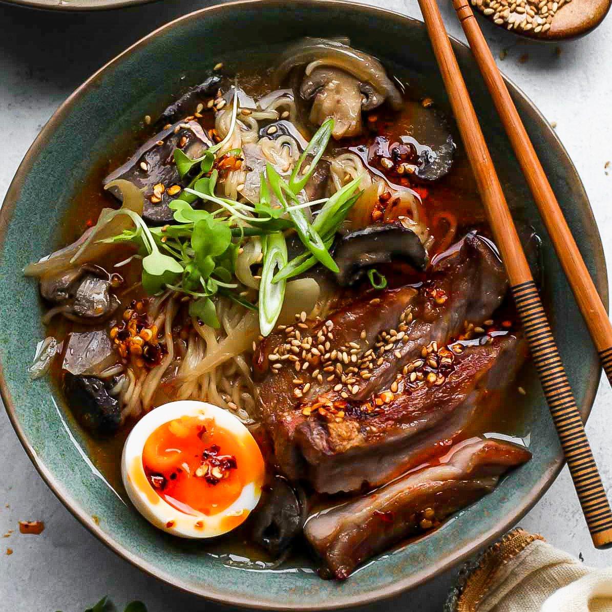 Close-up shot of a bowl of Slow Cooker Pulled Pork Ramen with chopsticks