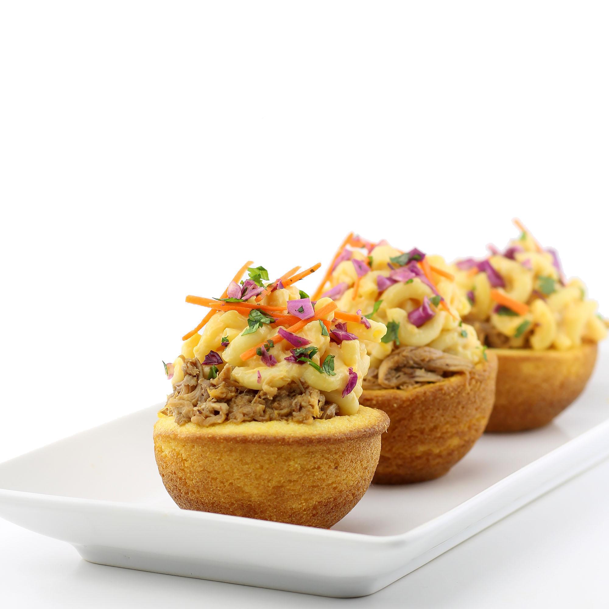 A family enjoying a meal together with Pulled Pork Mac and Cheese with Coleslaw as the centerpiece.