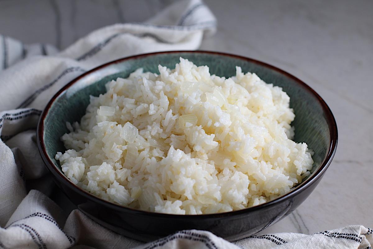 A bowl of fluffy boiled rice topped with sauteed onions