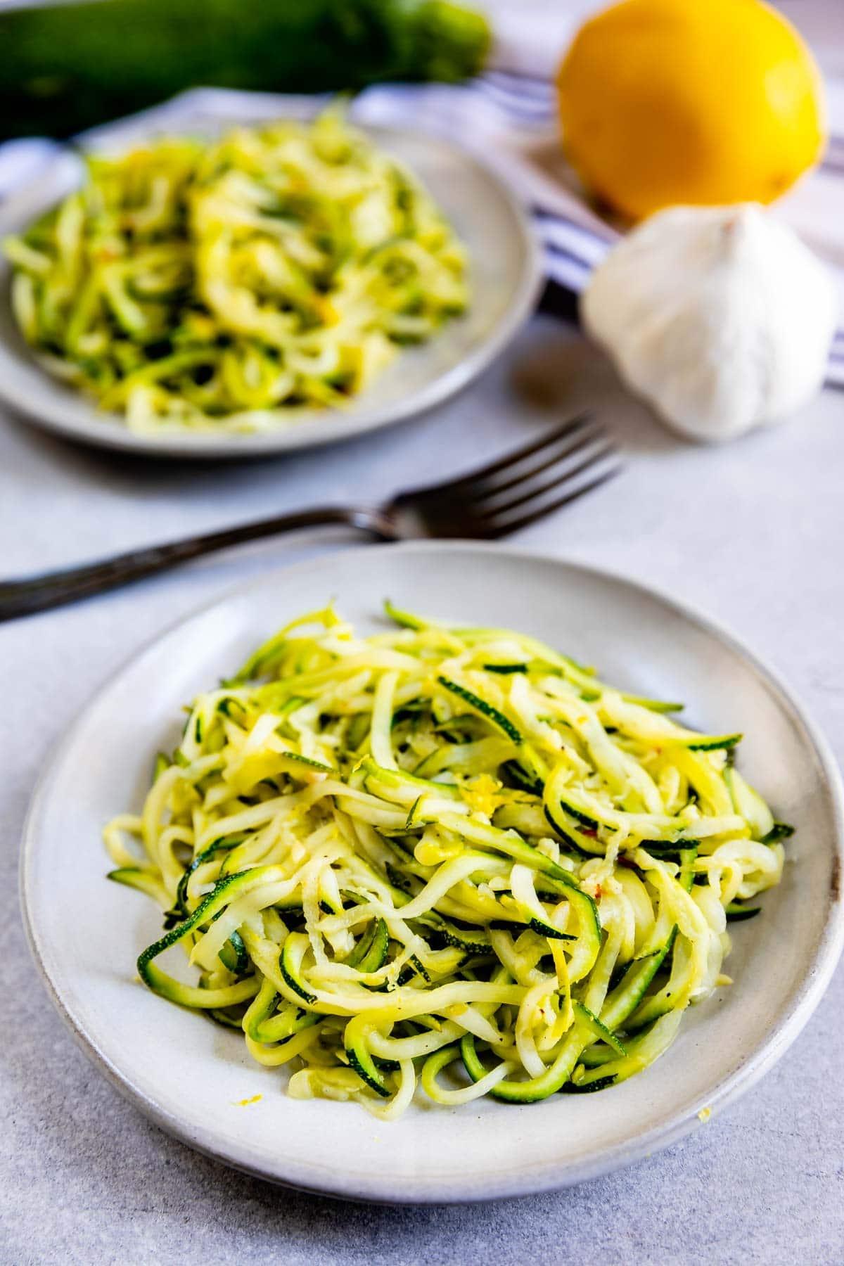 Close-up shot of a vibrant plate of zoodles with lemon-garlic butter sauce, garnished with fresh parsley