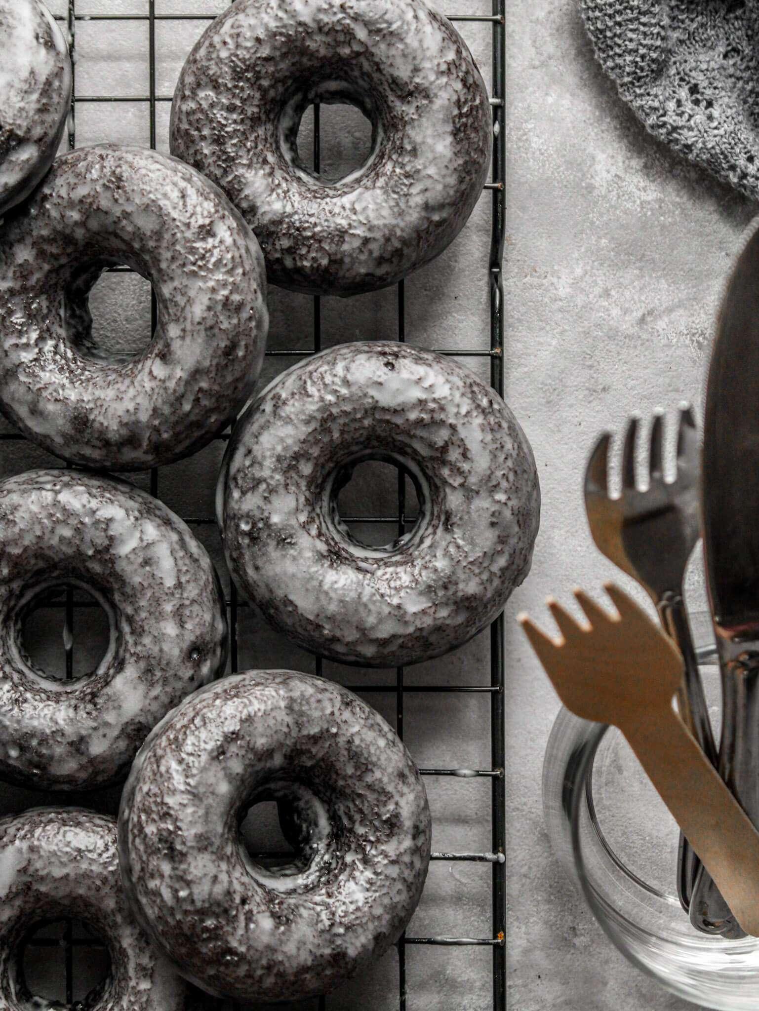 Close-up shot of a batch of freshly baked German chocolate donuts on a wire rack