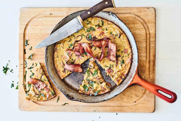 A close-up shot of a slice of Bacon & Caramelized Onion Leftover Frittata, showing the texture of the bacon and onions.