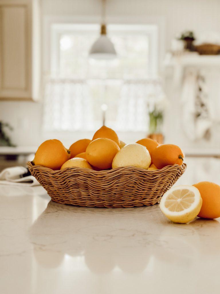 A rustic kitchen setting with a bowl of lemons and ginger