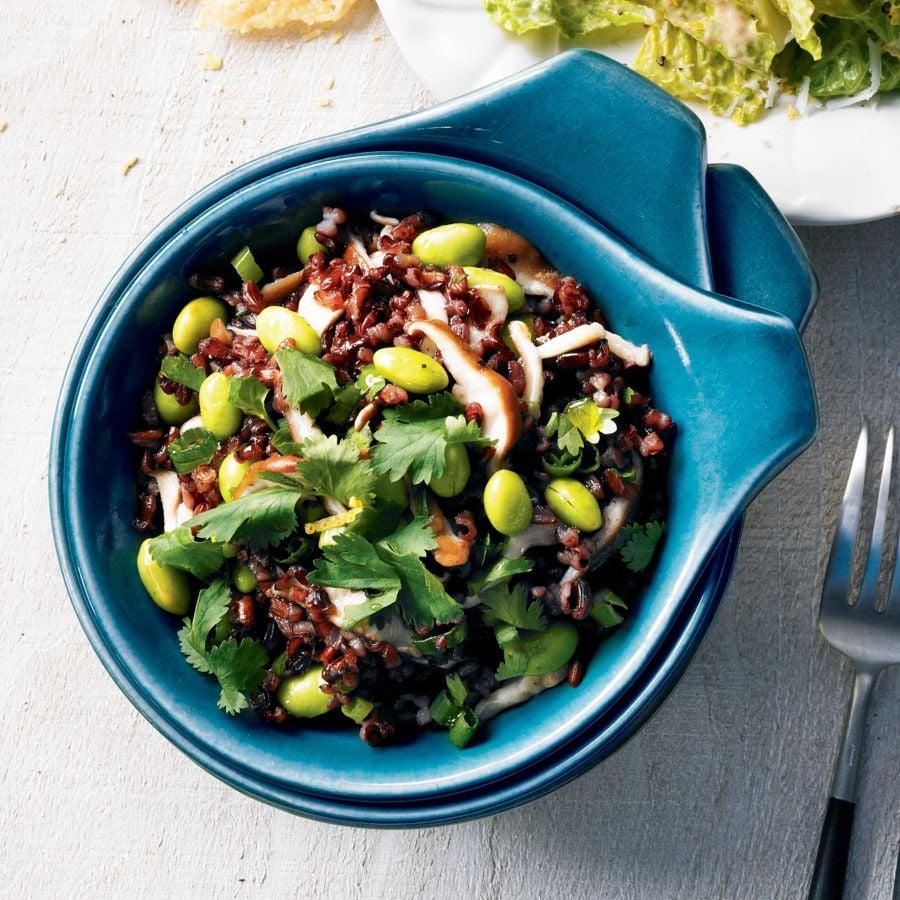 Overhead shot of a beautifully assembled black rice bowl with vibrant green edamame and creamy avocado