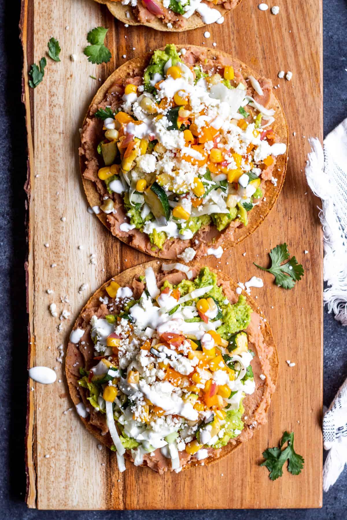 overhead shot of freshly baked cilantro lime flatbreads stacked on a wooden plate