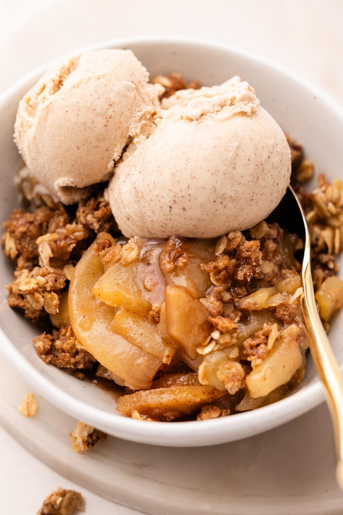 A rustic apple crisp with a pecan pie crust, golden brown and bubbling, served warm with a scoop of vanilla ice cream