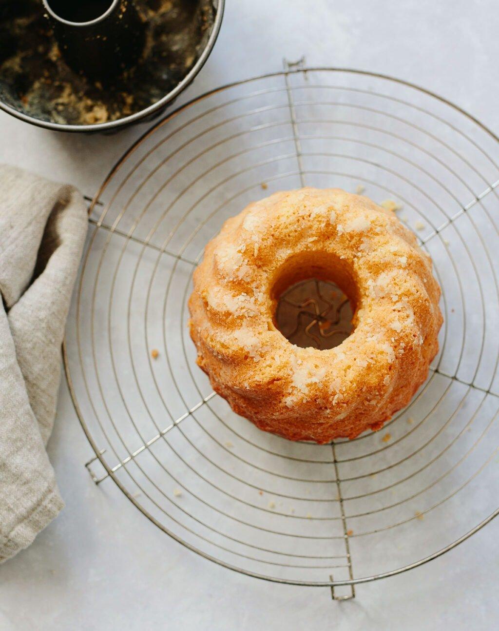 A whole lemon semolina cake on a cooling rack