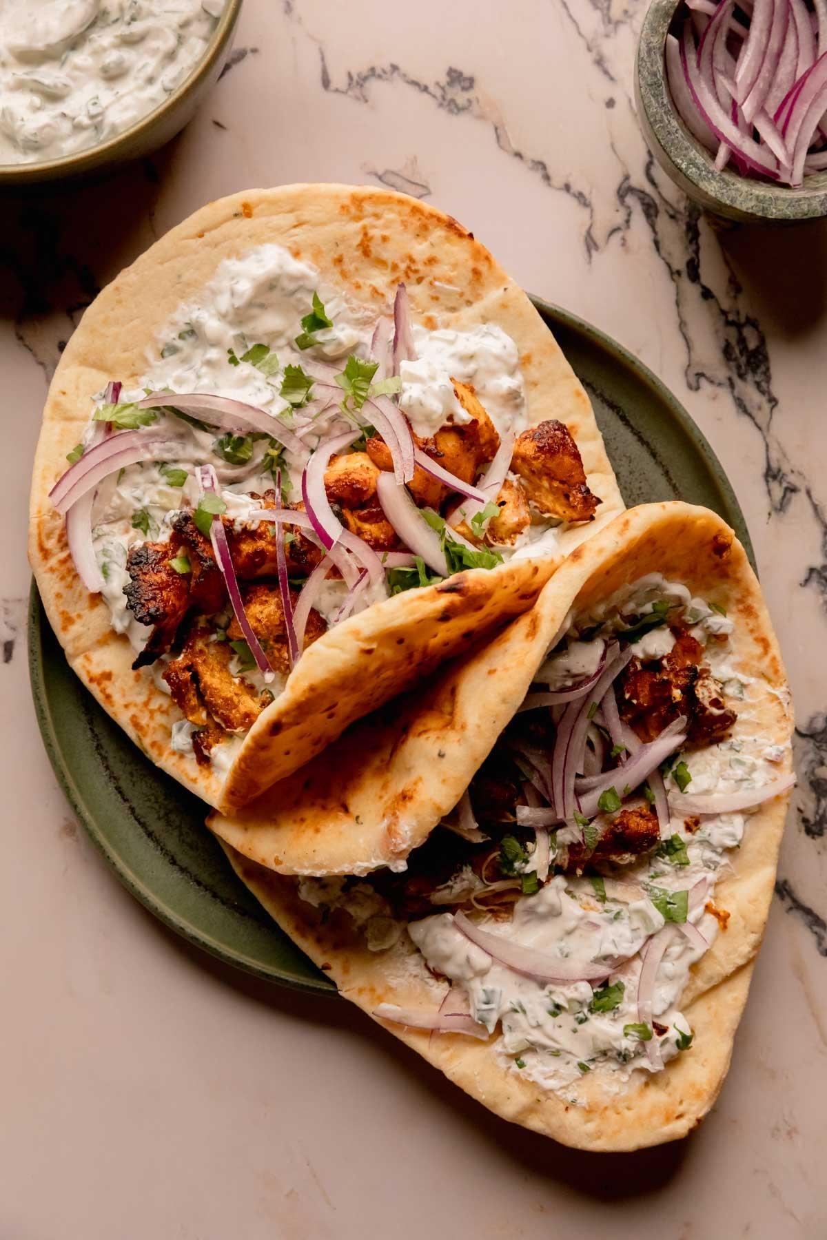 A person enjoying a Chicken Tikka Masala Wrap with Raita
