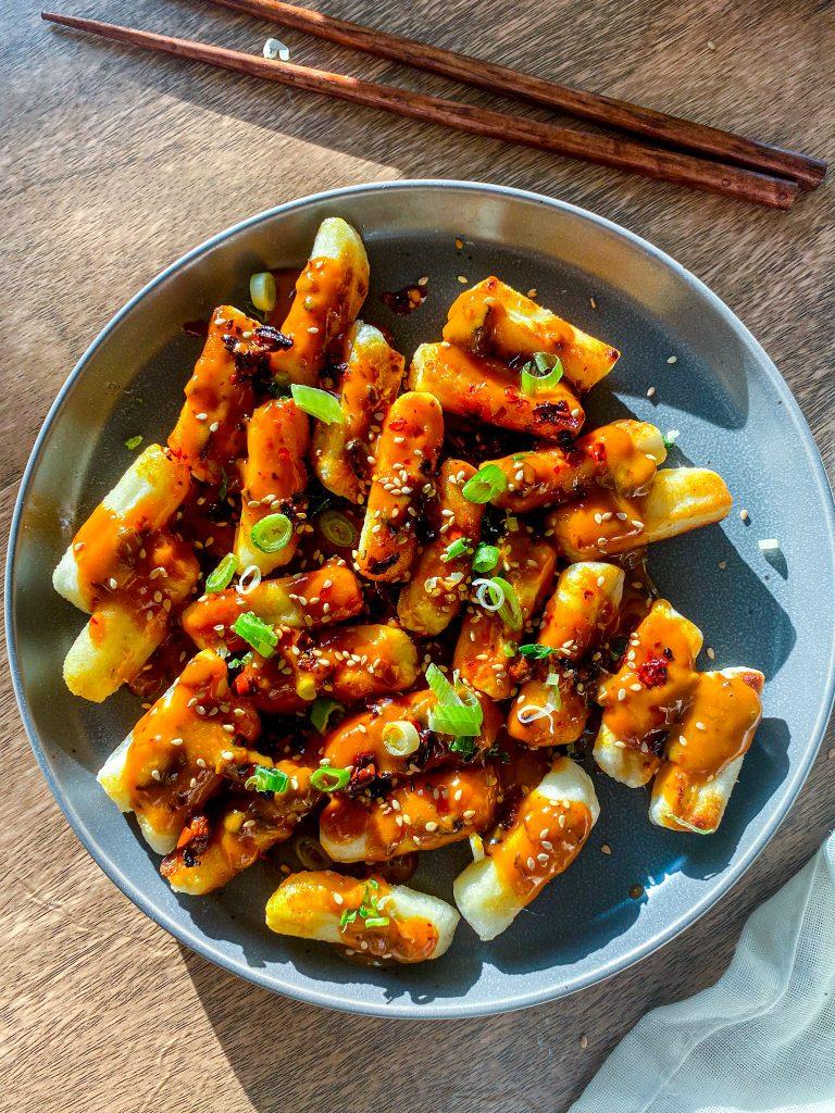 hands dipping rice crackers into spicy peanut dip