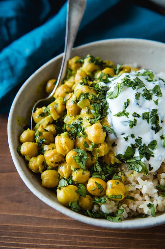 bowl of chickpea curry topped with coconut yogurt and fresh mint