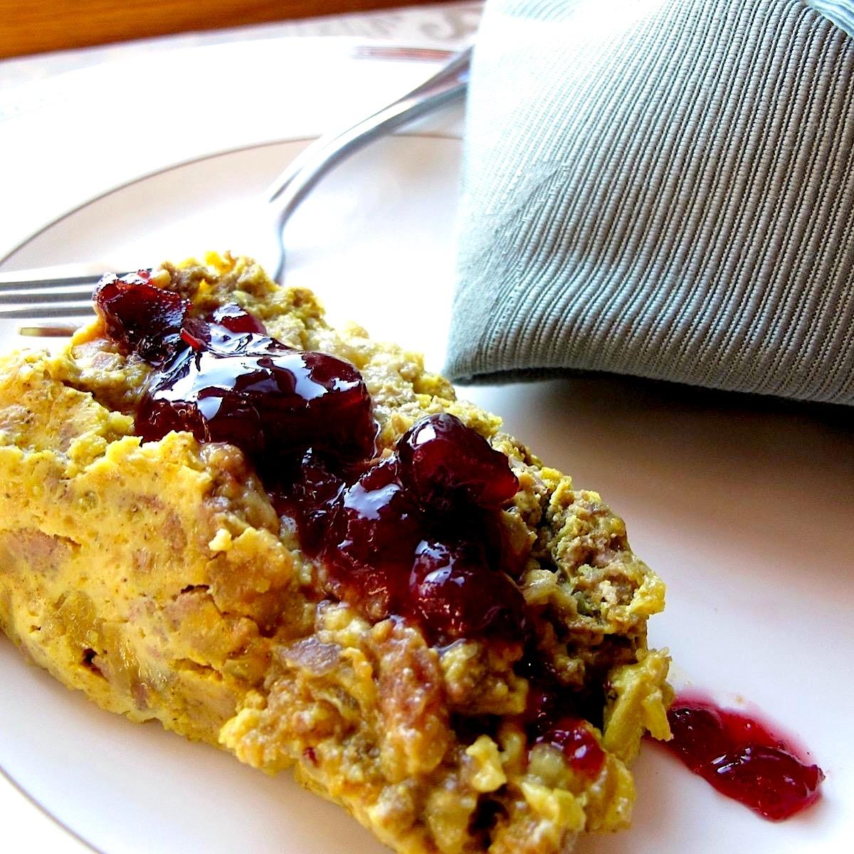 Close-up shot of Bobotie with a tangy orange and ginger glaze, showing the golden-brown topping and rich meaty filling