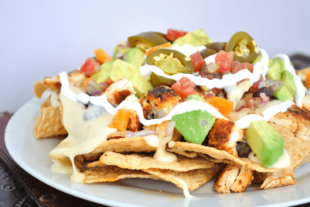Close up shot of a plate of nachos with blackened chicken