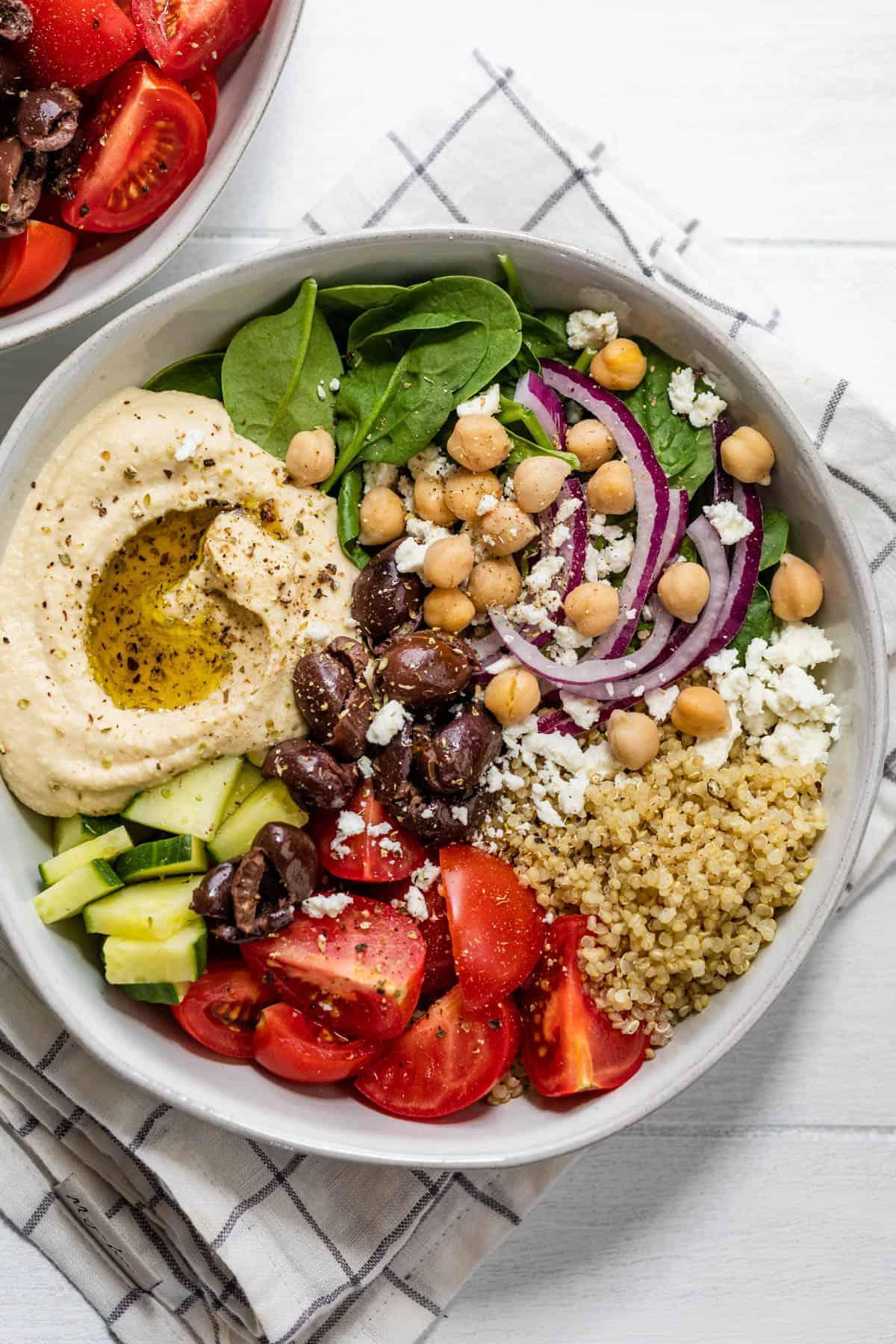 A bowl of hummus with various fresh vegetables