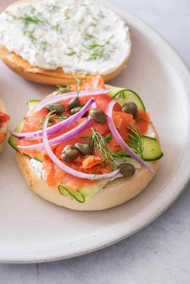 Close-up of various bagel toppings: cream cheese, smoked salmon, capers, red onion, dill