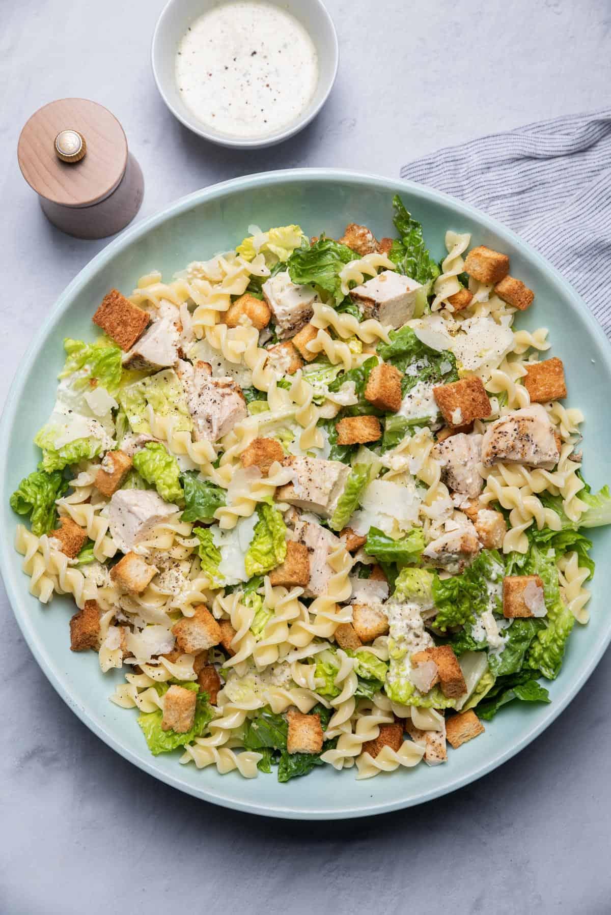 Close-up shot of a bowl of Chicken Caesar Pasta Salad, highlighting the texture and ingredients