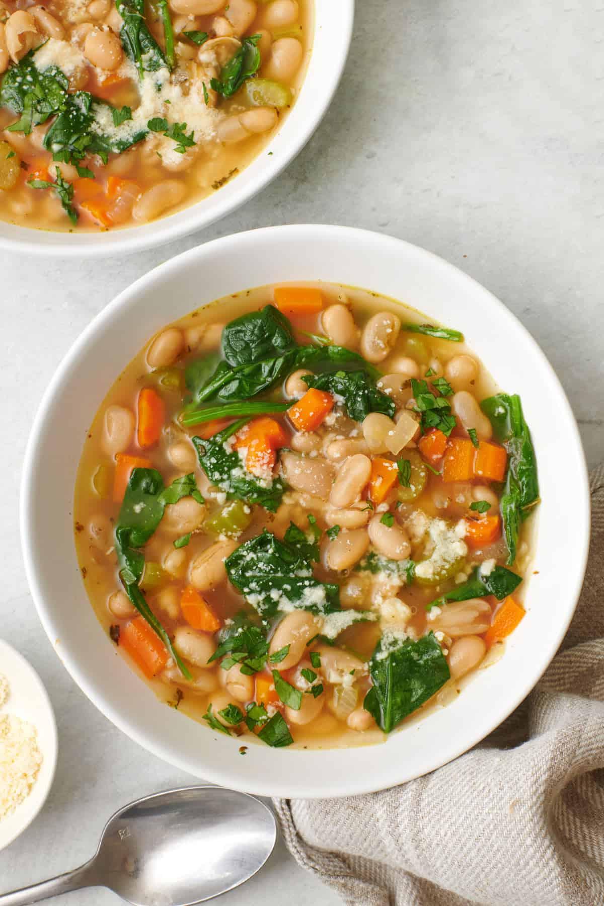 A close-up shot of a bowl of Great Northern beans with fresh herbs