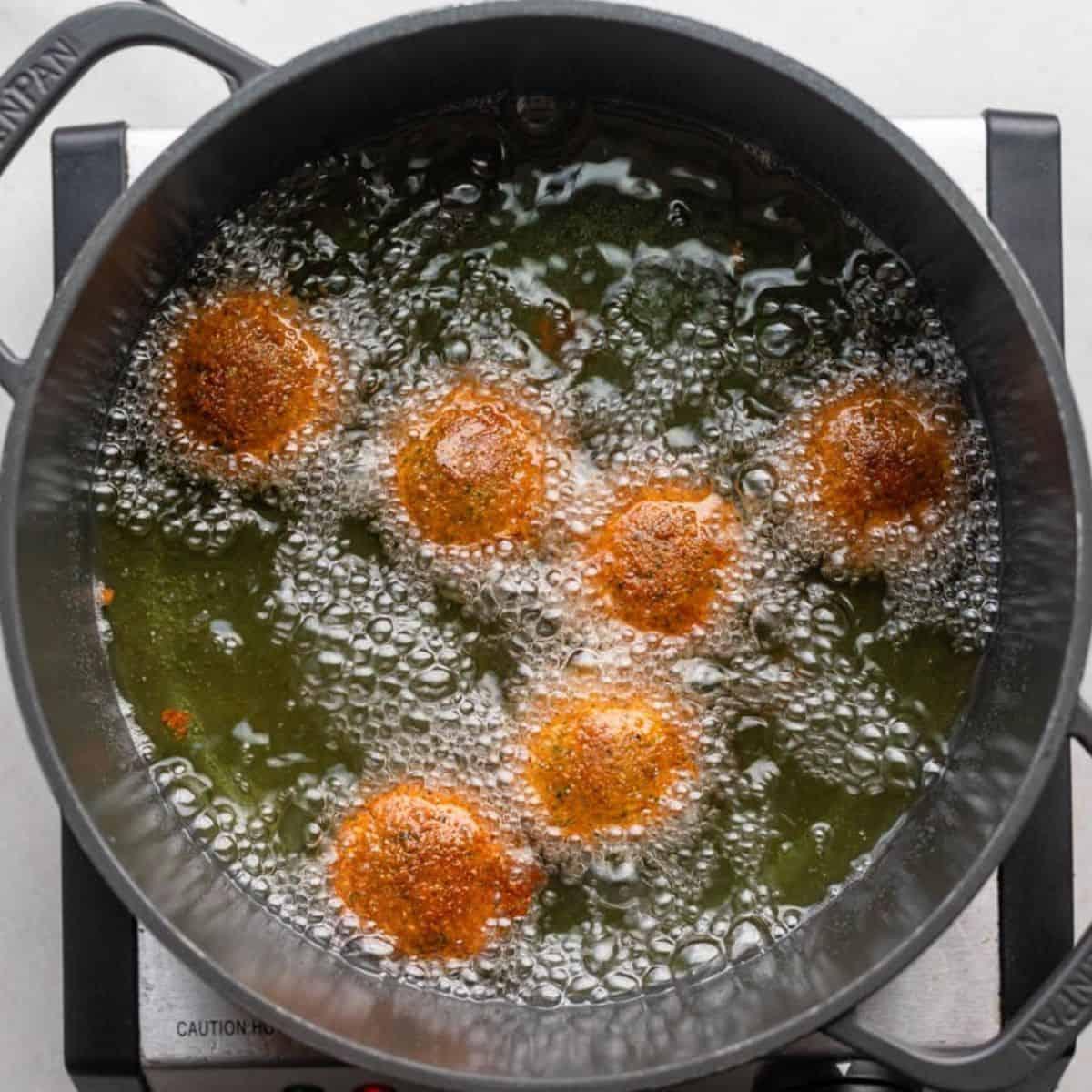 Close-up shot of falafel being fried in a skillet