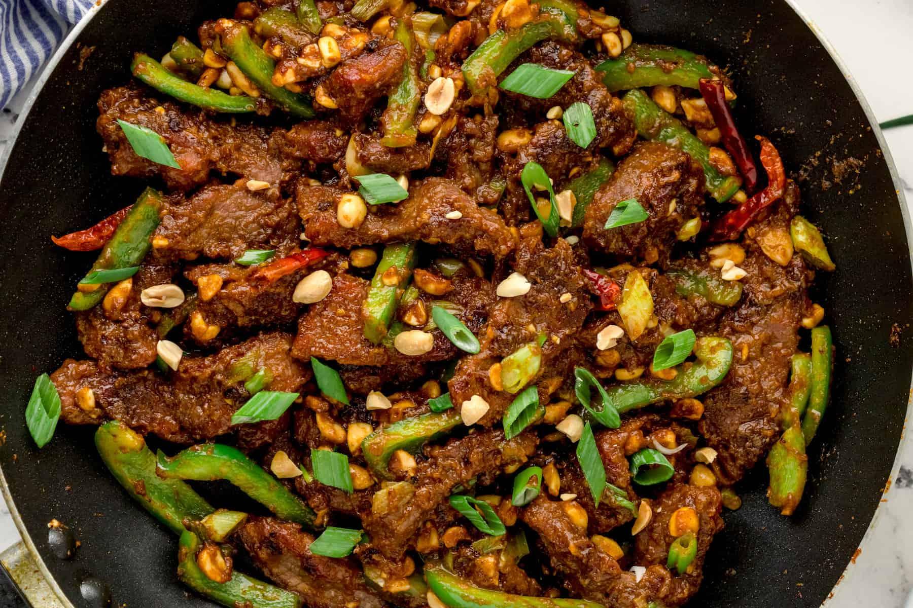 close-up of steak with hoisin sauce, peanuts, and green onions