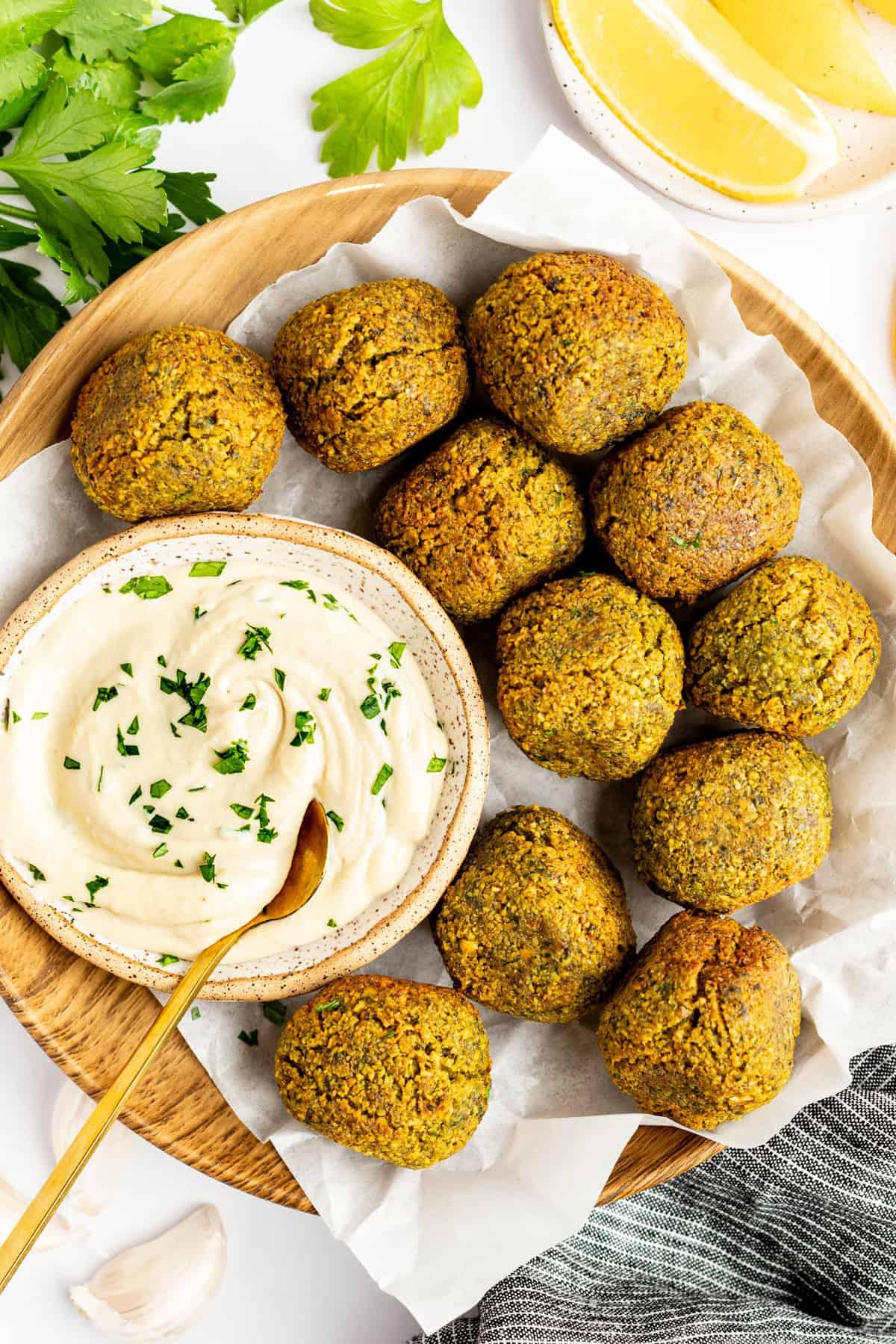 A plate of vibrant golden falafel, garnished with fresh parsley and a squeeze of lemon