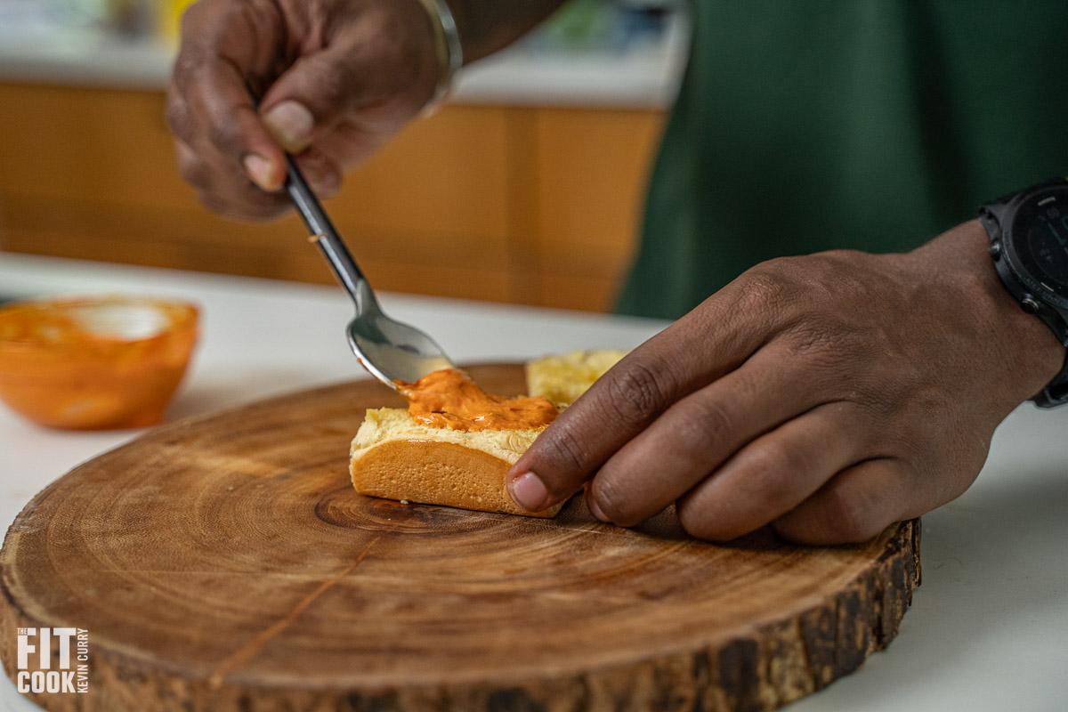 A close-up shot of a person assembling teriyaki salmon sliders.