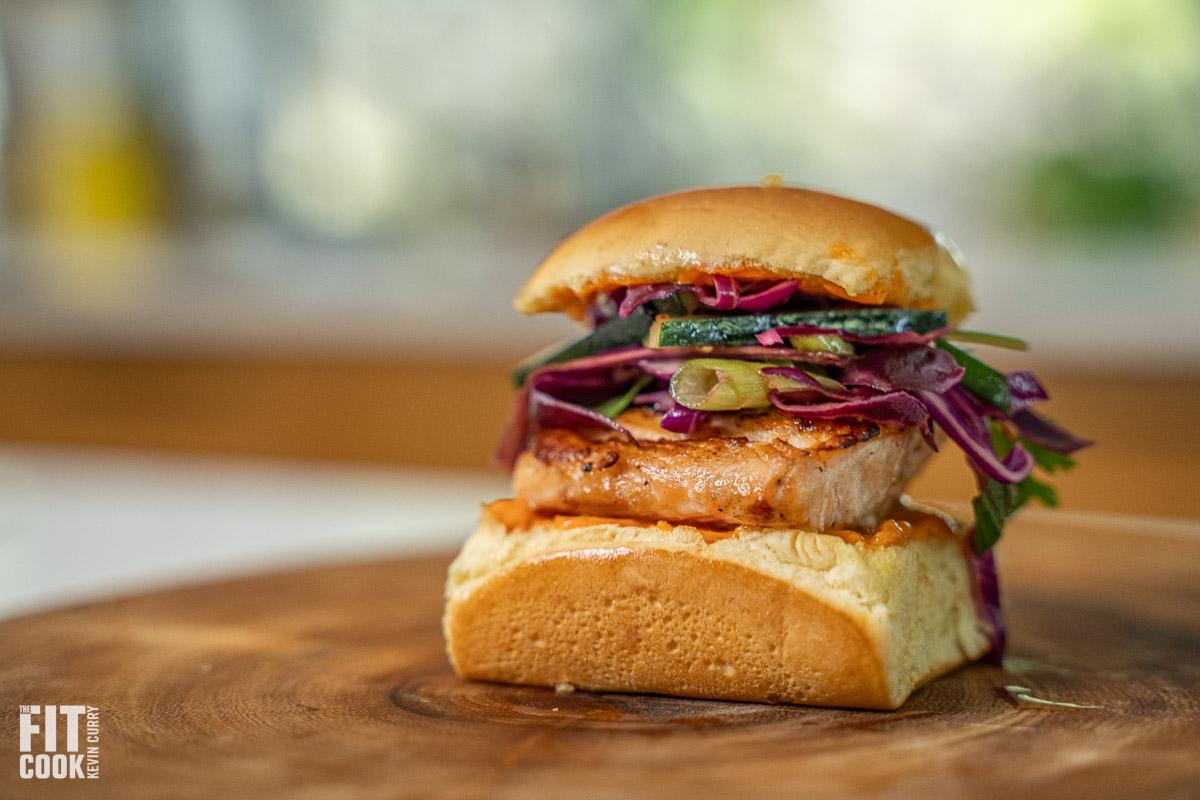 Close-up shot of delicious teriyaki salmon sliders on slider buns, garnished with sesame seeds.