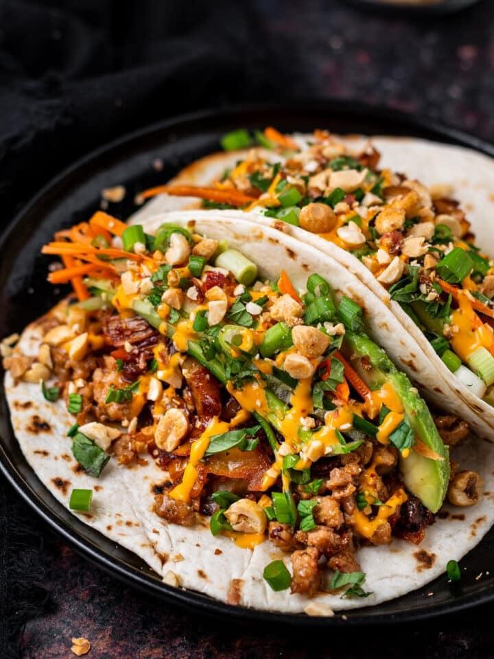 A person enjoying a plate of kimchi and chicken tacos