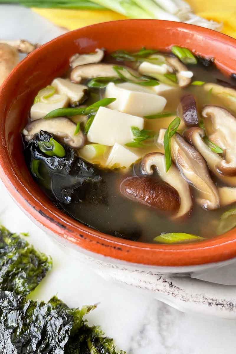 Close-up shot of a bowl of Miso soup with baby corn and mushrooms