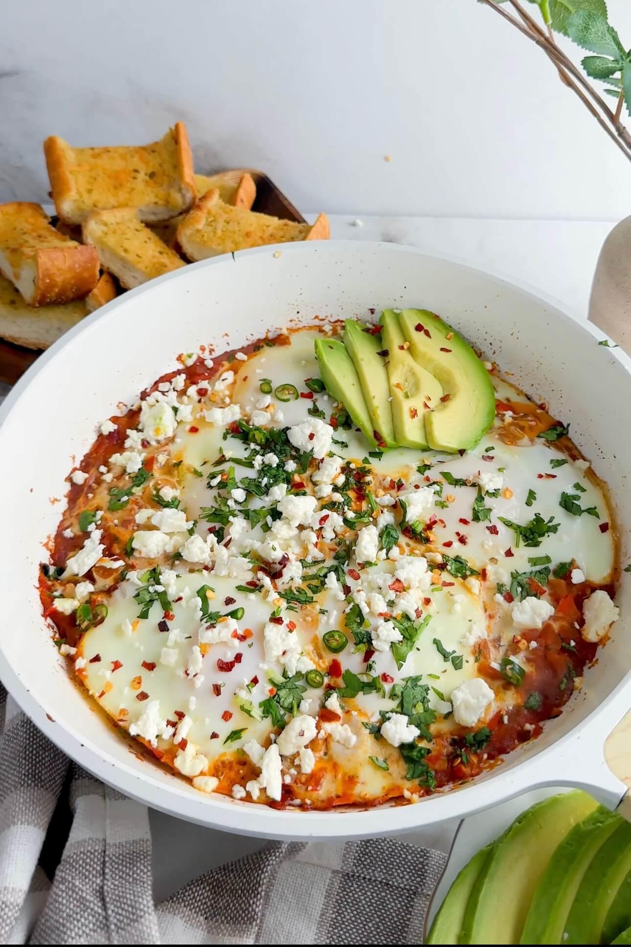 A vibrant and appetizing close-up shot of shakshuka with crème fraîche and chives, showcasing the rich colors and textures of the dish.
