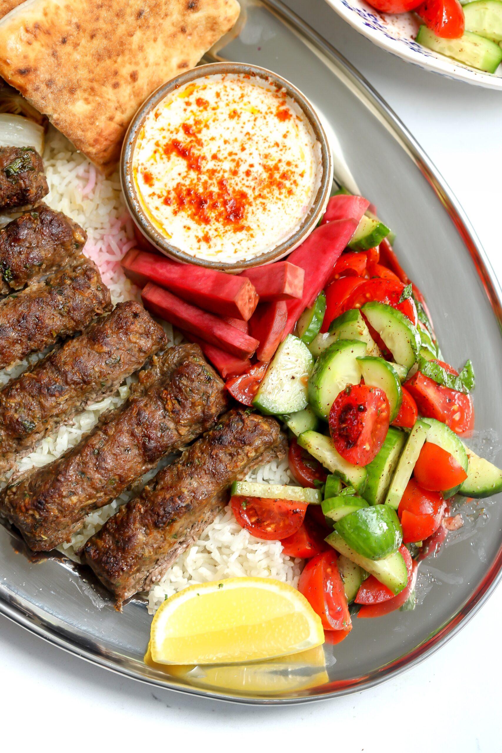 Beef kebabs served on a platter with a side salad