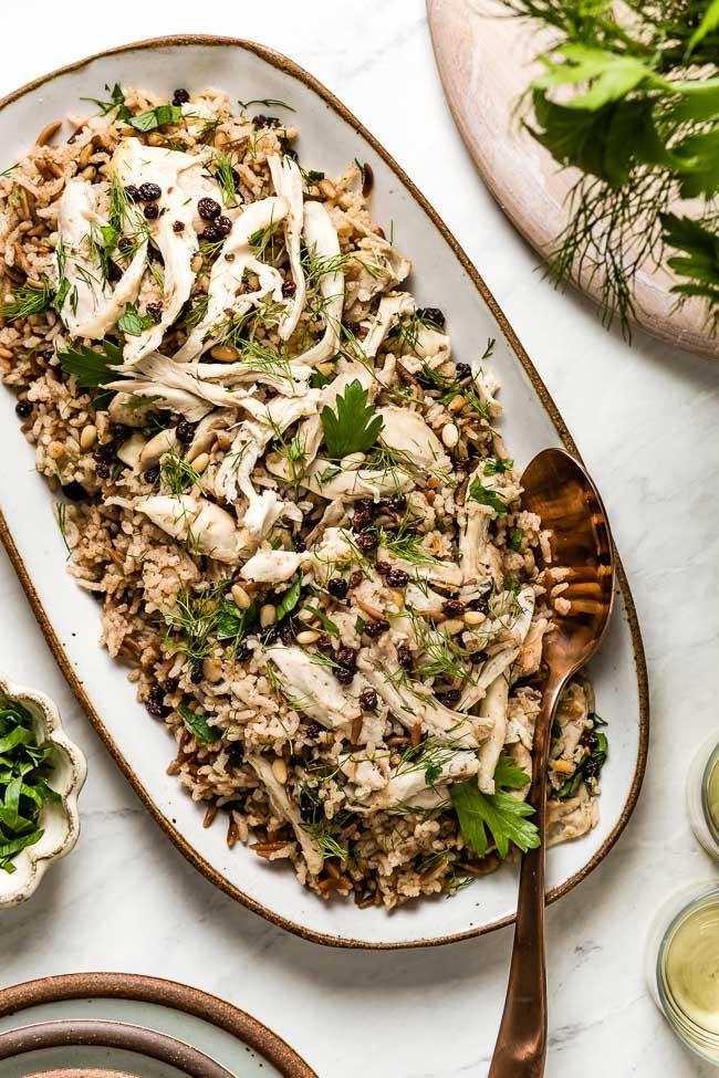 A beautifully plated bowl of steamed rice and Turkish pilav, garnished with fresh herbs