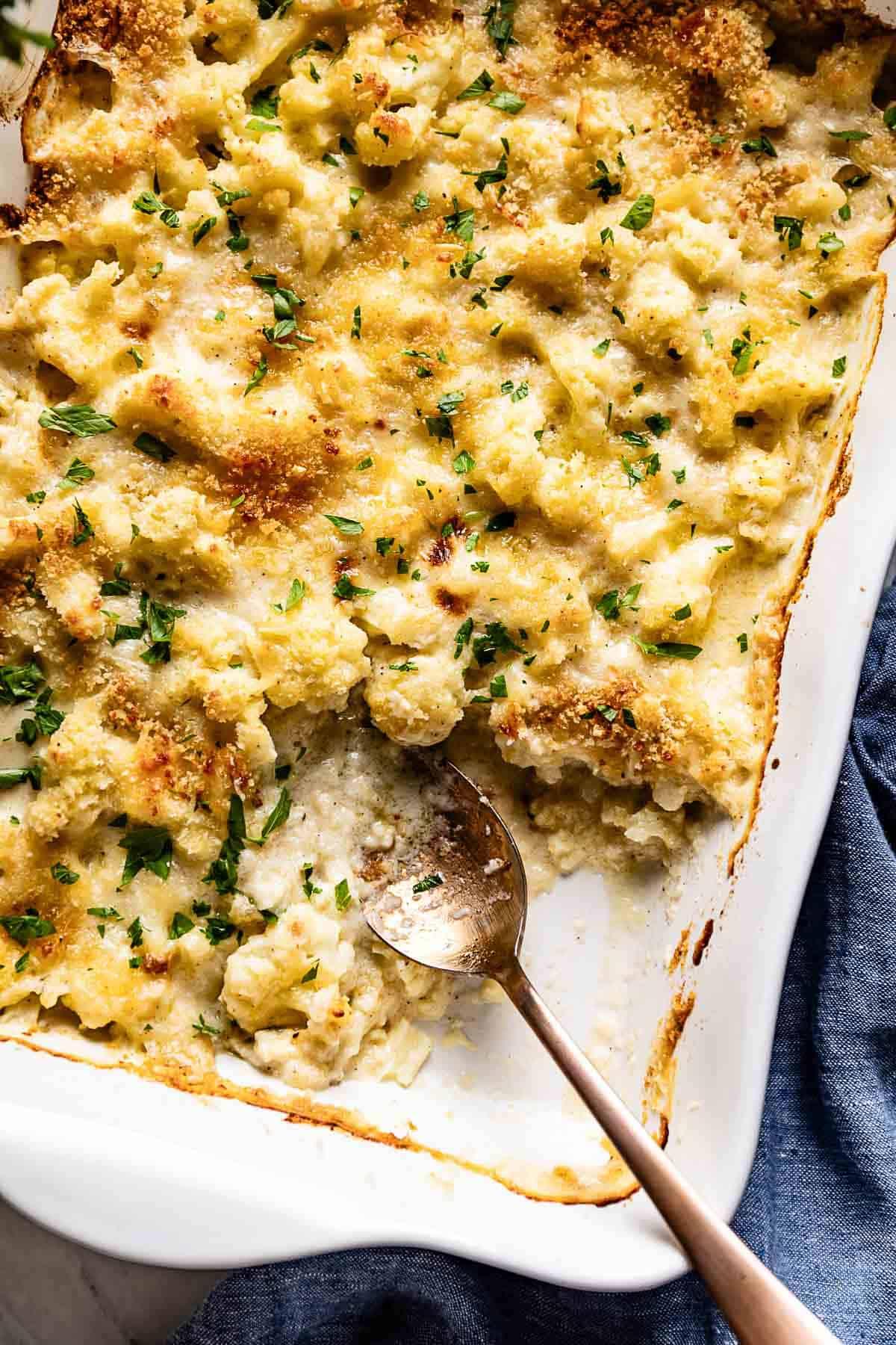 A golden-brown gratin of squash and cauliflower, bubbling cheese on top.