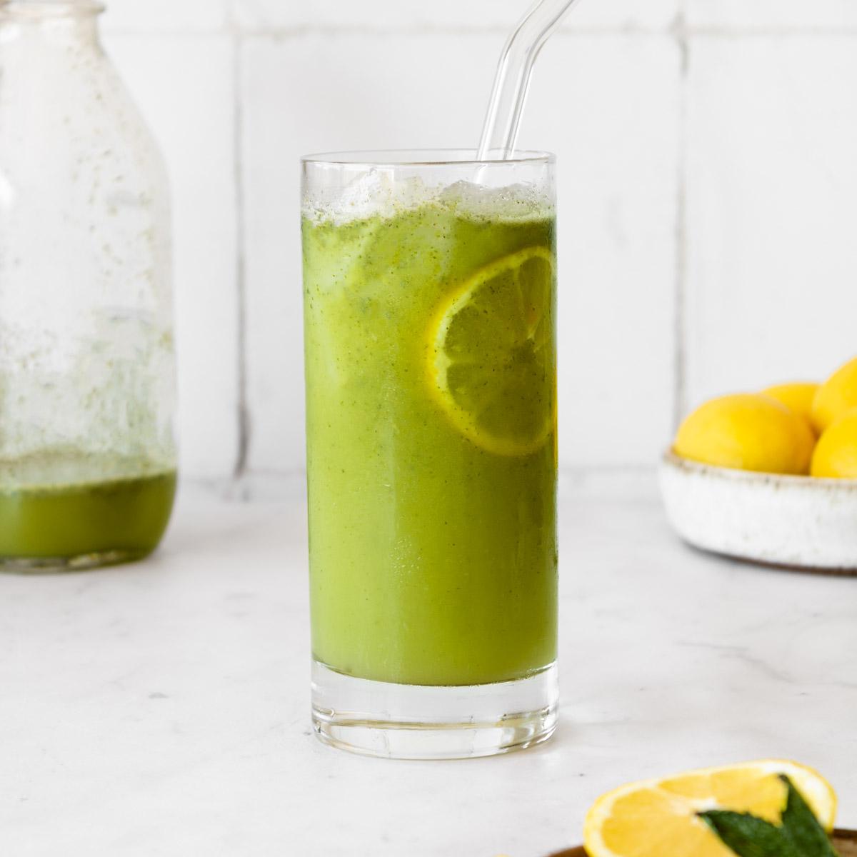 Refreshing glass of green apple mint lemonade with ice and mint sprigs