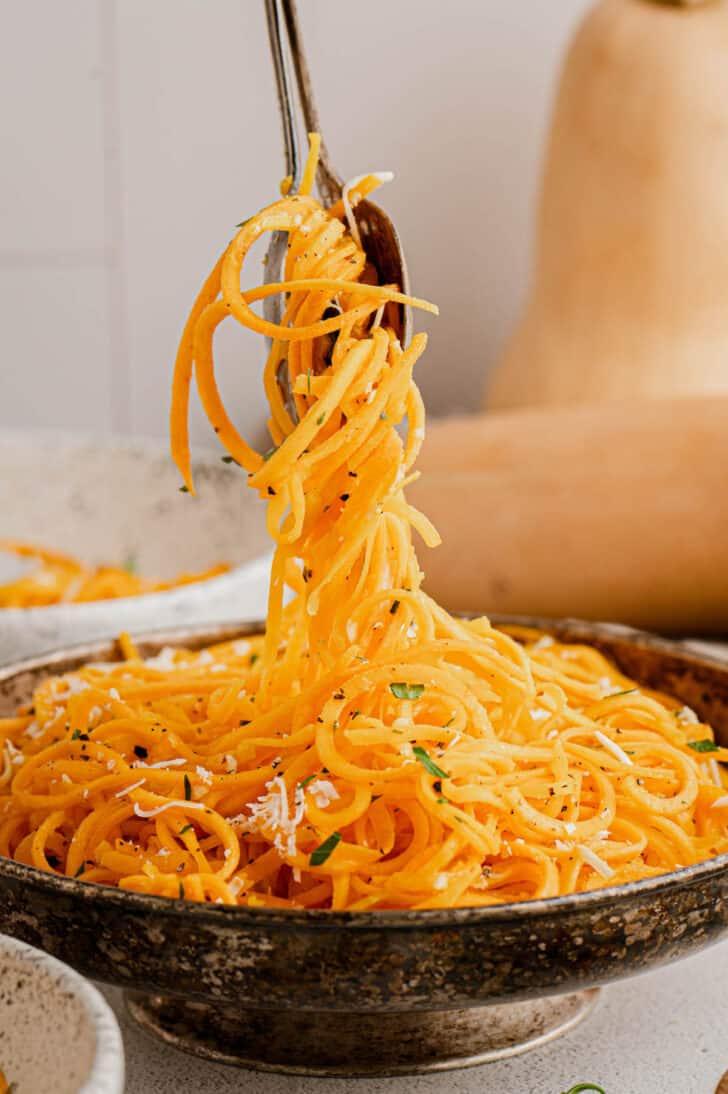a person twirling butternut squash pasta with a fork